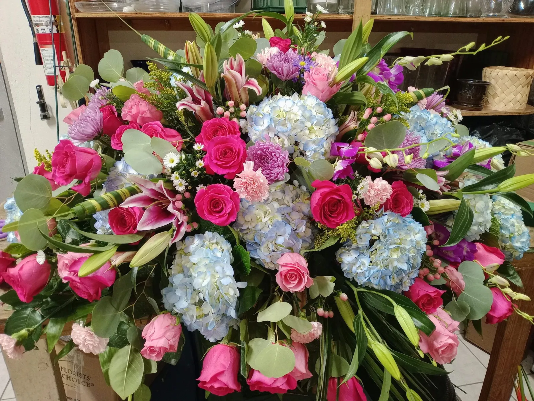 Large floral arrangement of pink roses, blue hydrangea and lilies designed by Creative Avenues in Nassau