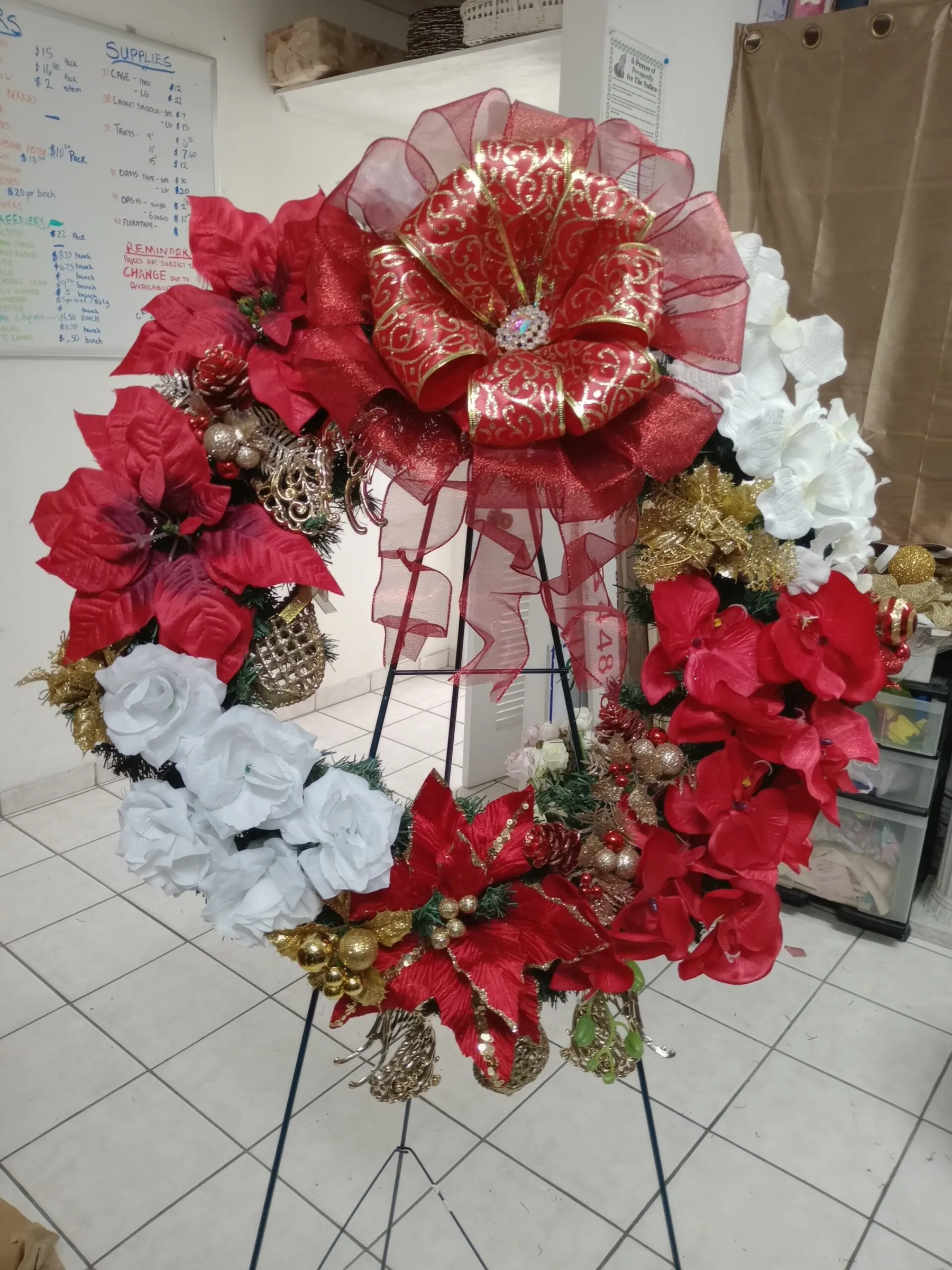 Standing sympathy wreath of red flowers finished with a large bow by Creative Avenues
